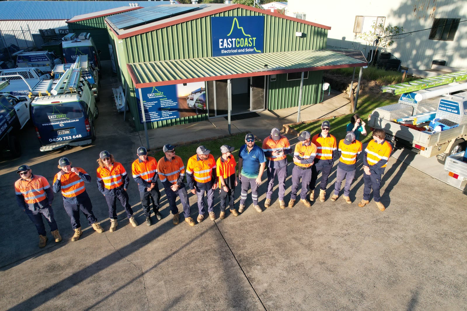 The East Coast Electrical and Solar team lined up outside their Maryborough workshop